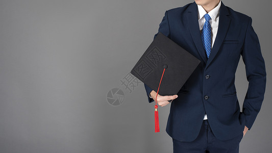 男商人手上持有毕业帽子背景图片