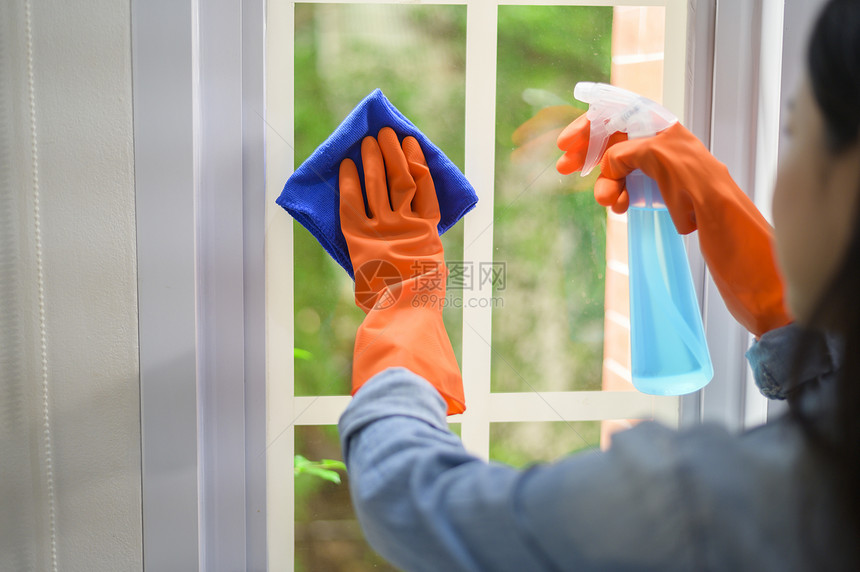 一名妇女使用清洁手套酒精喷雾清洁剂洗房屋卫生图片