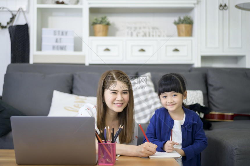 AsiaHappy母女使用笔记本电脑在家中通过互联网上学习图片