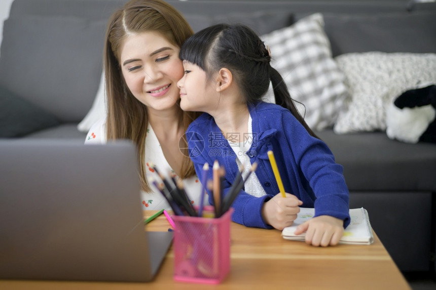 AsiaHappy母女使用笔记本电脑在家中通过互联网上学习图片