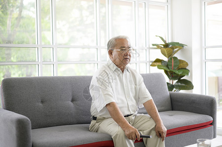 老人在家中客厅沙发上看电视的亚洲老人退休概念图片
