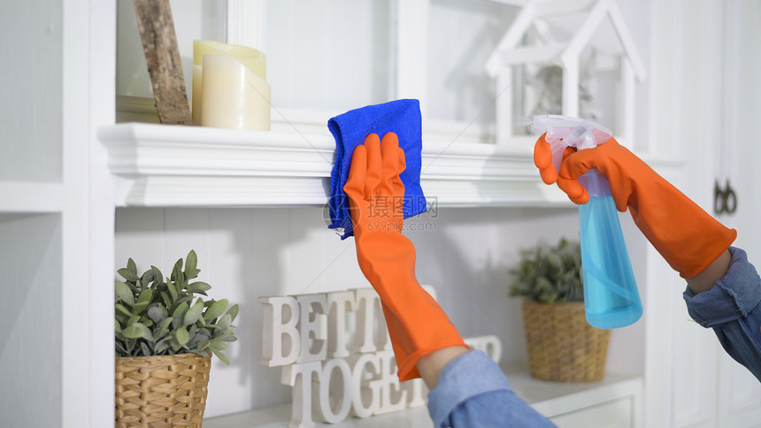 一名妇女使用清洁手套酒精喷雾清洁剂洗房屋卫生图片