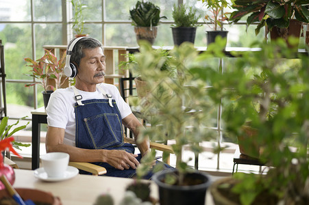 快乐的亚洲退休老人在家里听音乐和享受休闲活动图片