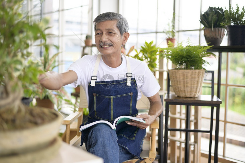 快乐的亚洲退休老人在家里花园阅读和享受休闲活动图片
