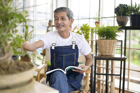 快乐的亚洲退休老人在家里花园阅读和享受休闲活动图片