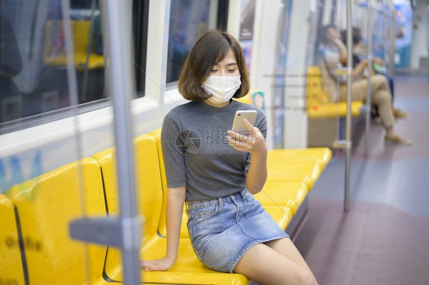 年轻女在地铁上戴保护面具在公用地铁上戴保护面具在安全旅行上戴保护面具在安全旅行上戴保护面具图片