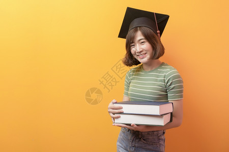 短发女青年带着毕业帽手上抱着书图片