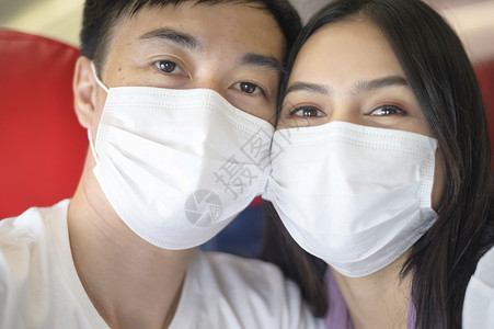 旅行夫妇戴着口罩乘坐飞机图片