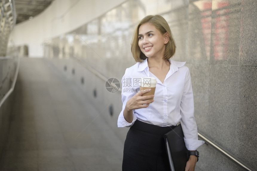 美丽的年轻白人女商在现代城市工作的肖像图片