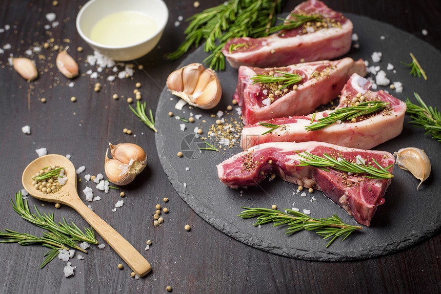 黑石板上木桌的石板新鲜生牛肉和原料排图片