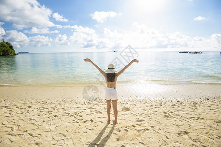 一个快乐的美丽女人在黄色比基尼享受和放松在海滩夏天和节假日的概念图片