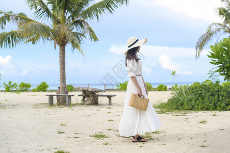 凉鞋白裙子一个穿着白裙子的快乐美丽女人在海滩夏天和节假日享受放松背景