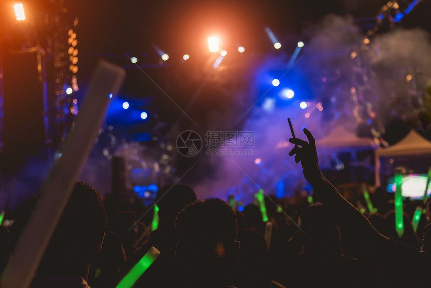 音乐会人群节们举起手来拉着舞台灯图片