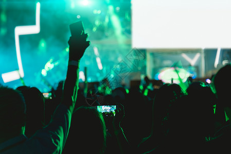 音乐会人群节在舞台灯上使用移动智能手机背景图片