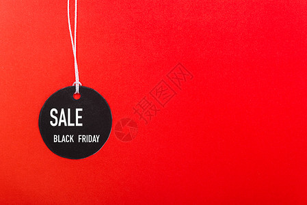 黑周五网上购物销售文本贴在红背景的黑标签上有复制空间图片