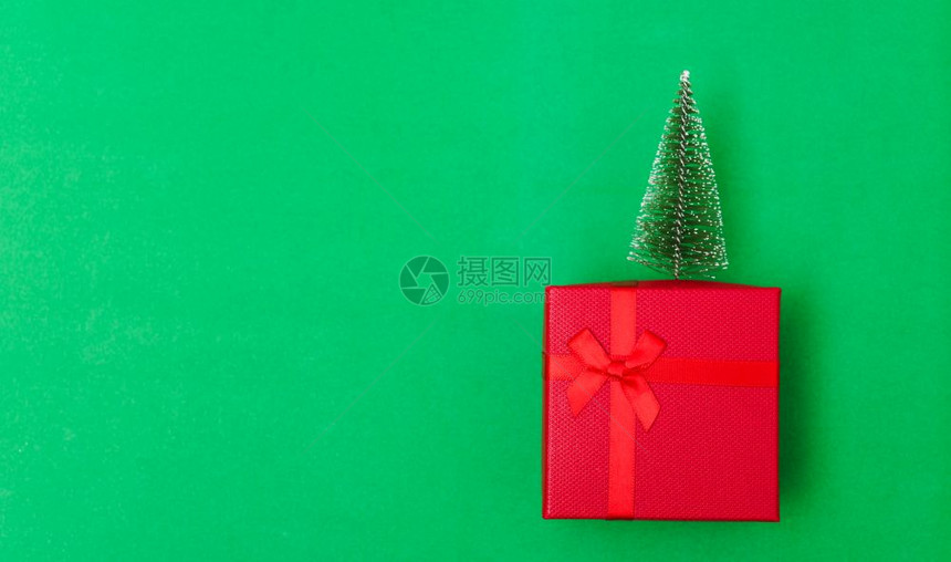 新年圣诞节组成顶视红礼品盒绿树枝在色背景的盒子上加绿色fir树枝图片