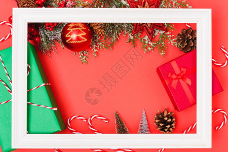 圣诞组合装饰白色相框方形红色背景上有冷杉树枝圣诞快乐复制文本空间图片