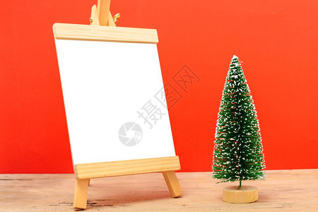 圣诞成像装饰最小绿色fir树枝红底有雪和白黑纸板圣诞快乐概念文本复制空间背景图片