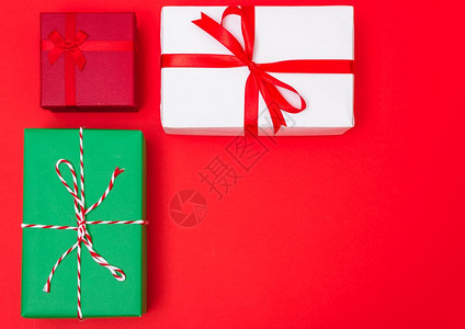 新年快乐和圣诞20日红背景的Xmas多彩礼品盒带有文本复制空间背景图片