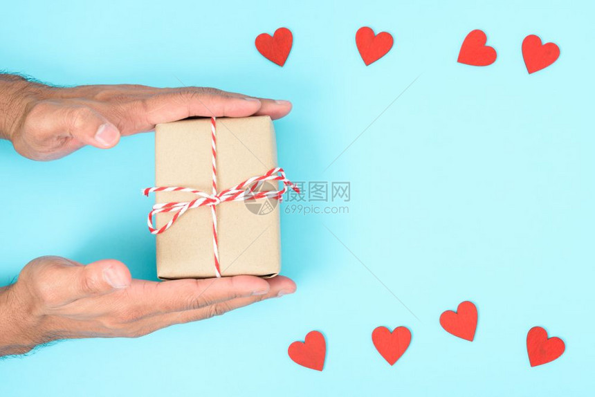 情人节的概念顶端视野平坦红心和手拿着礼物盒放在蓝背景的色上并抄写文本空间图片