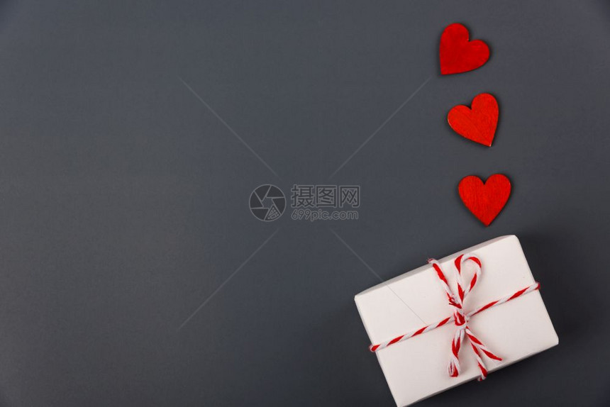 概念平面最直视白色礼物盒和红心放在灰色背景并附上文本的复制空间图片