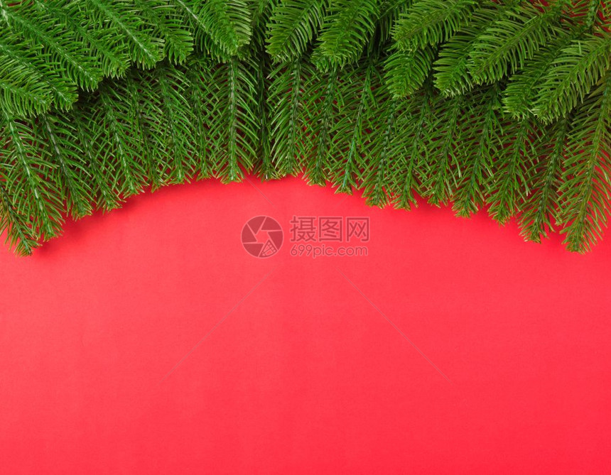新年或圣诞节快乐最上方的视野平地在红背景上铺立fir树枝并复制文本空间图片