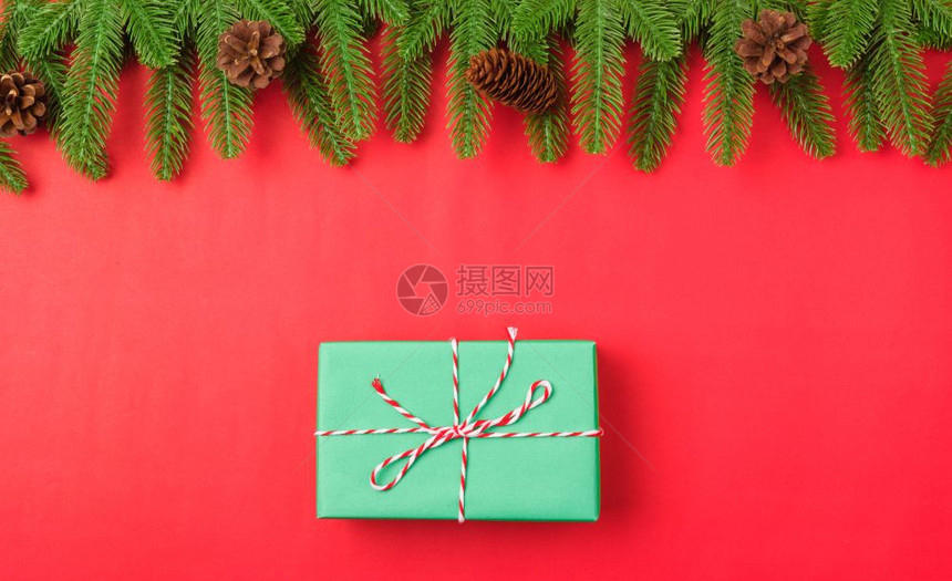 新年或圣诞节快乐最上方的视野平铺放fir树枝和礼品盒装饰红色背景并装饰您文本的复制空间图片