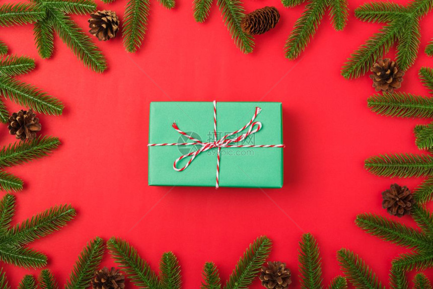 新年或圣诞节快乐最上方的视野平铺放fir树枝和礼品盒装饰红色背景并装饰您文本的复制空间图片