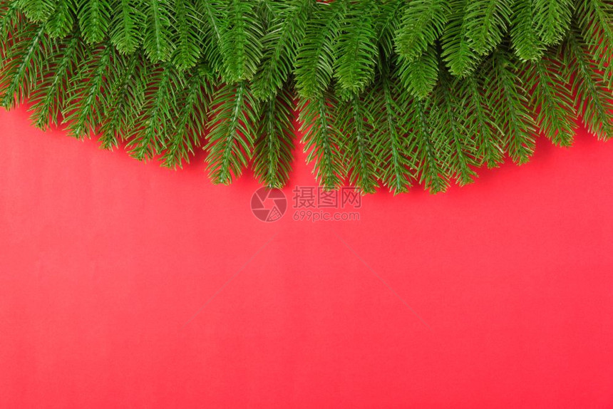 新年或圣诞节快乐最上方的视野平地在红背景上铺立fir树枝并复制文本空间图片