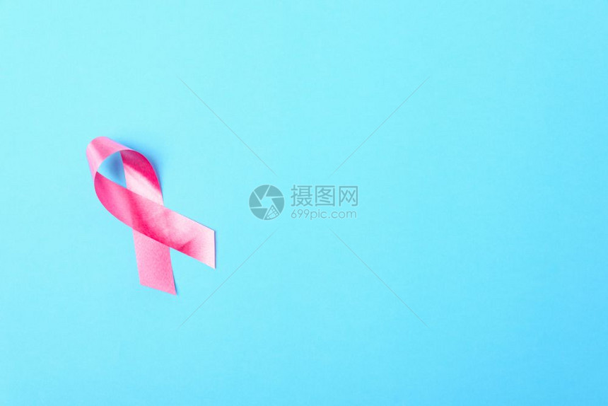 乳癌月概念平坦的顶部视野蓝色背景的粉丝带并附上文本的复制空间图片