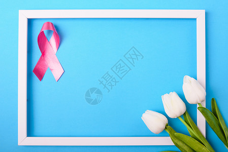 乳癌月概念平铺顶楼粉色丝带图利普花蓝色背景照片框和文本复制空间背景图片