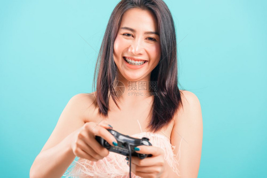 笑脸肖像一个美丽的女人一样微笑着脸部肖像她在蓝色背景上快乐地玩电子游戏并有复制文本的空间图片