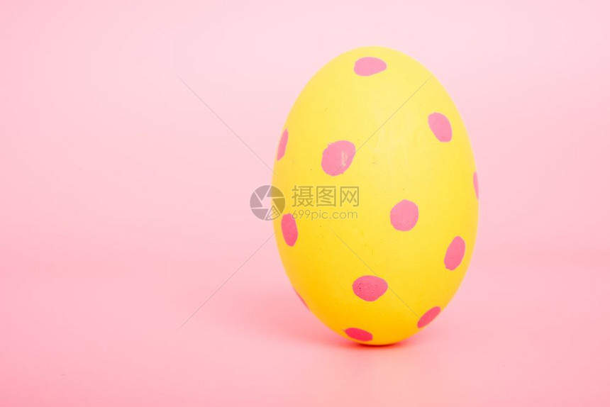粉红色背景的美丽复活节黄蛋颜色复活节概念图片