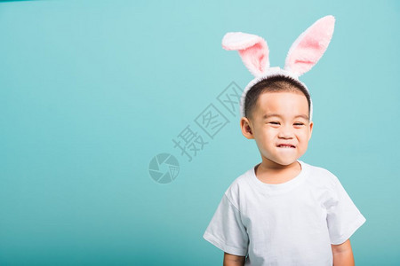 复活节概念快乐的亚洲可爱小男孩微笑带着兔子耳朵和白色T恤图片