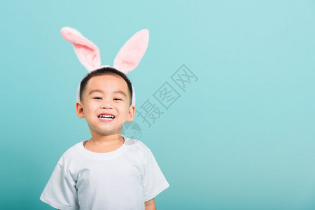 复活节概念快乐的亚洲可爱小男孩微笑带着兔子耳朵和白色T恤图片