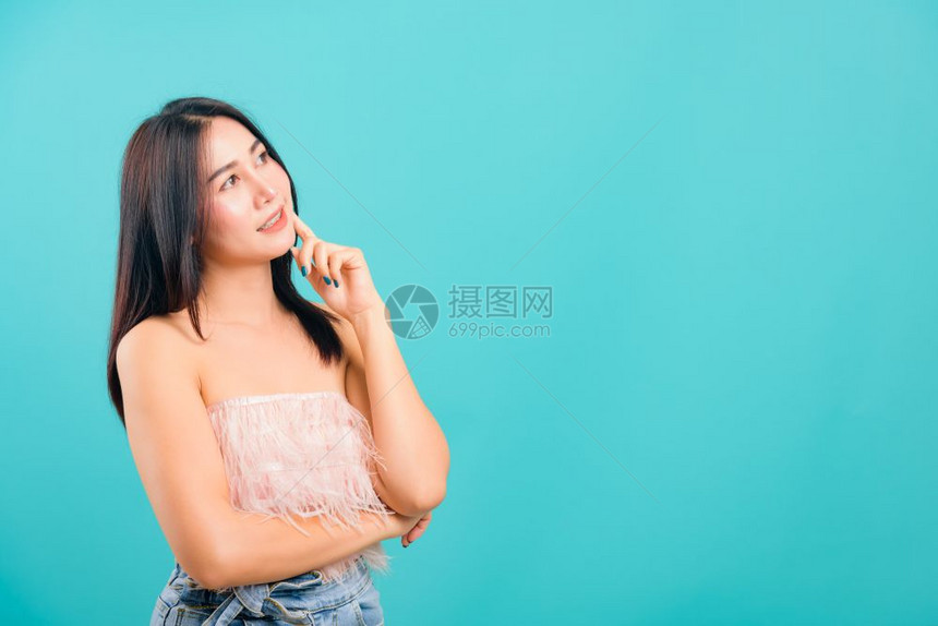 肖像般的亚洲美丽女微笑着她站立的看蓝背景复制文本空间图片