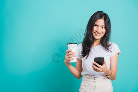 使用手机拿着咖啡纸杯寻找蓝色背景的相机背景图片
