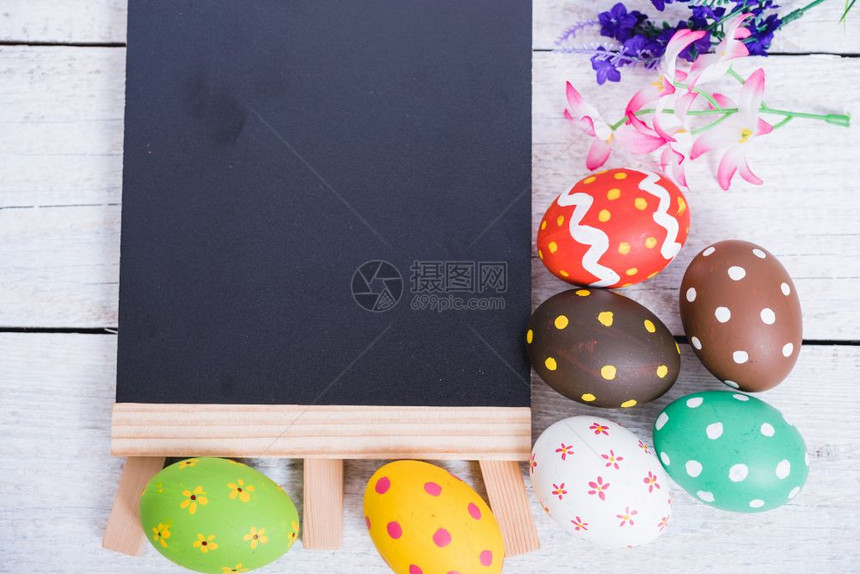白木背景的复活鸡蛋和黑板图片