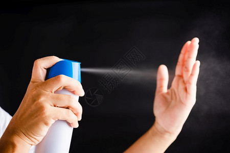 防烫手使用喷泵洒器清洗手时喷洒净化剂酒精防卫生COVID19或以黑色背景隔离的冠状保护概念的亚洲青年妇女背景