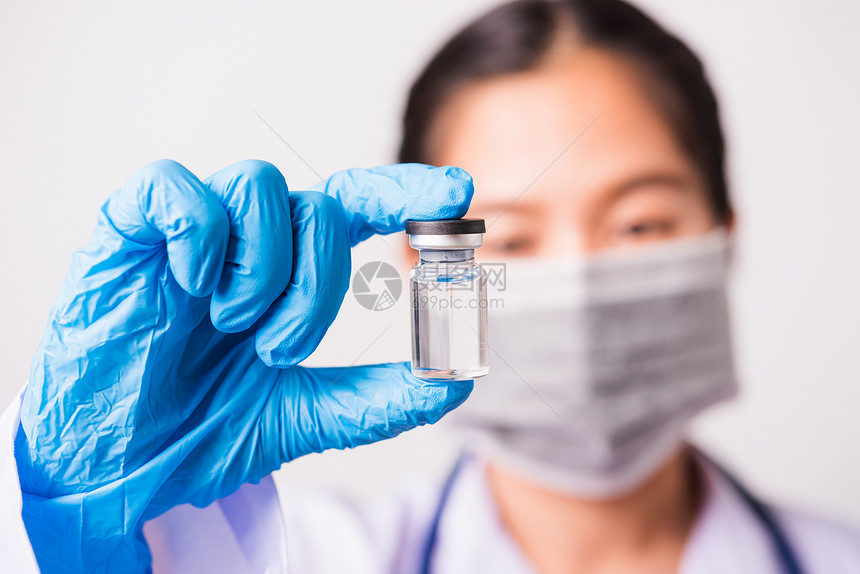 身穿医生制服的女或科学家紧的手身戴面罩在实验室内佩戴防面罩持有药品液体疫苗瓶冠状或COVID19概念制片室被单独拍摄图片