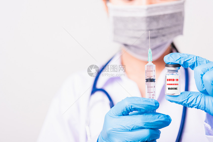 身着制服和手套的亚洲女医生或护士身戴面罩保护在实验室中持有针头注射器药物和瓶疫苗子上都有COVID19VACCINE的文字标签图片