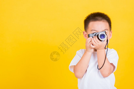 小男孩拿着照相机拍照图片