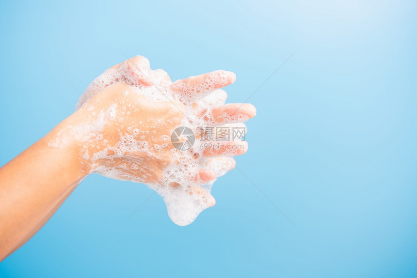 亚洲青年妇女用肥皂洗手时有泡沫卫生预防COVID19或冠状保护概念蓝底隔离图片