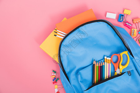 以粉红背景的学童返回校概念教育儿童的蓝包背图片