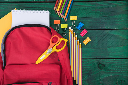 教育背景为绿色木的儿童返回学校概念的红背包图片