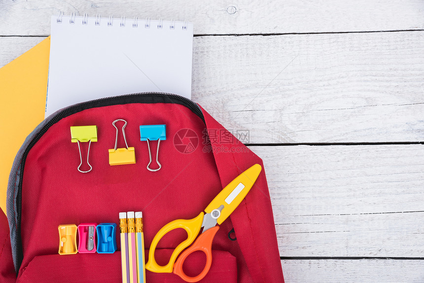 教育背景为白色木背景的儿童返回学校概念的红背包图片