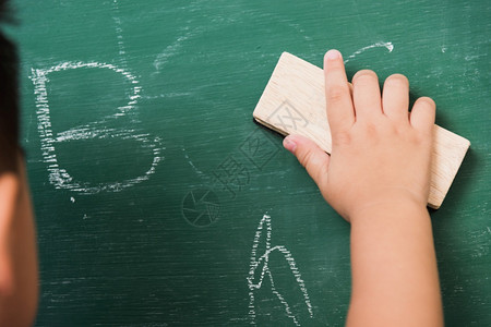 后亚洲可爱小男孩幼稚儿园校服擦干净或黑粉绿色学校板上用海绵擦粉第一次到学校教育概念背景图片