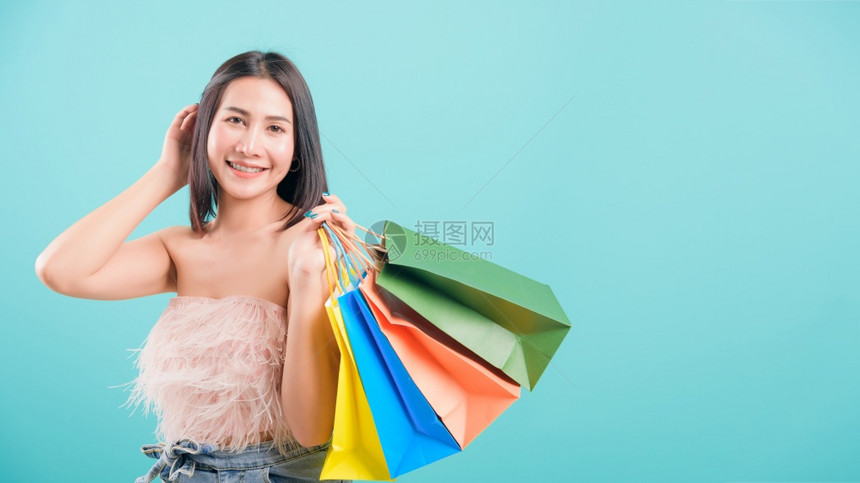 亚洲快乐肖像美丽的年轻女子站在夏天的微笑中购物她拿着多彩袋图片