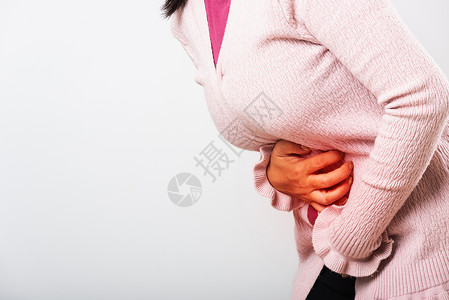 亚裔患病女有胃痛手握在腹部身体的一分女有痛苦的胃她有问题疾病是便或结肠背景图片