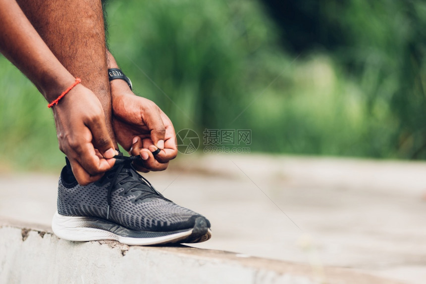 近亚洲运动赛跑的黑人在徒步路上站着手表尝试鞋带跑准备步和户外街头健康公园锻炼概念图片